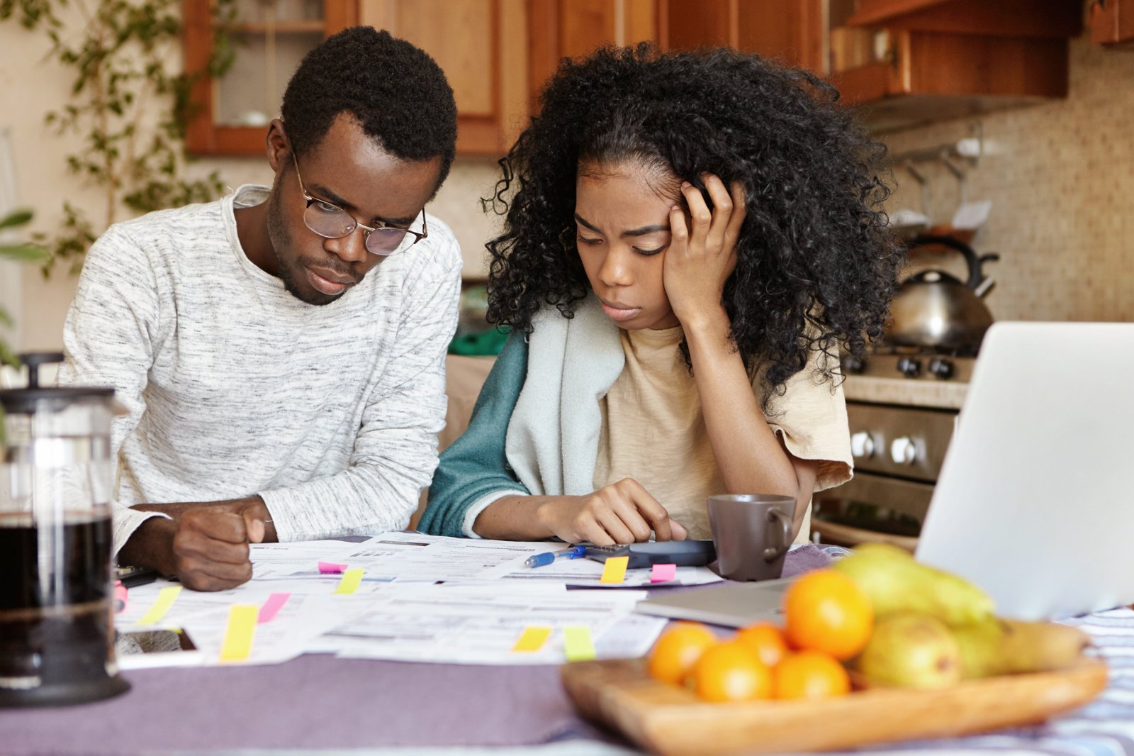 Two young adults reviewing bills together at a kitchen table